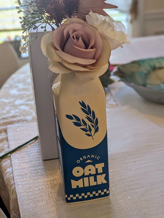 Decorative oat milk carton vase with artificial flowers, a quirky purchase that just kind of makes sense.