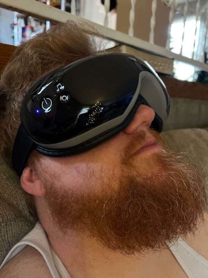 Man with red beard wearing a high-tech eye massager, an innovative Father's Day gift idea for relaxation and comfort.
