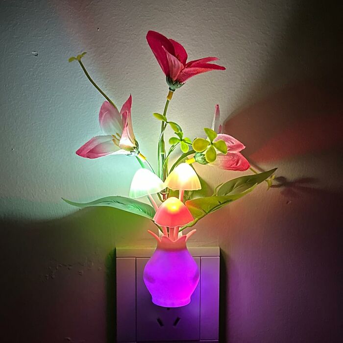 Colorful Amazon hidden gems night light shaped like mushrooms and flowers in a small vase plugged into a wall outlet.