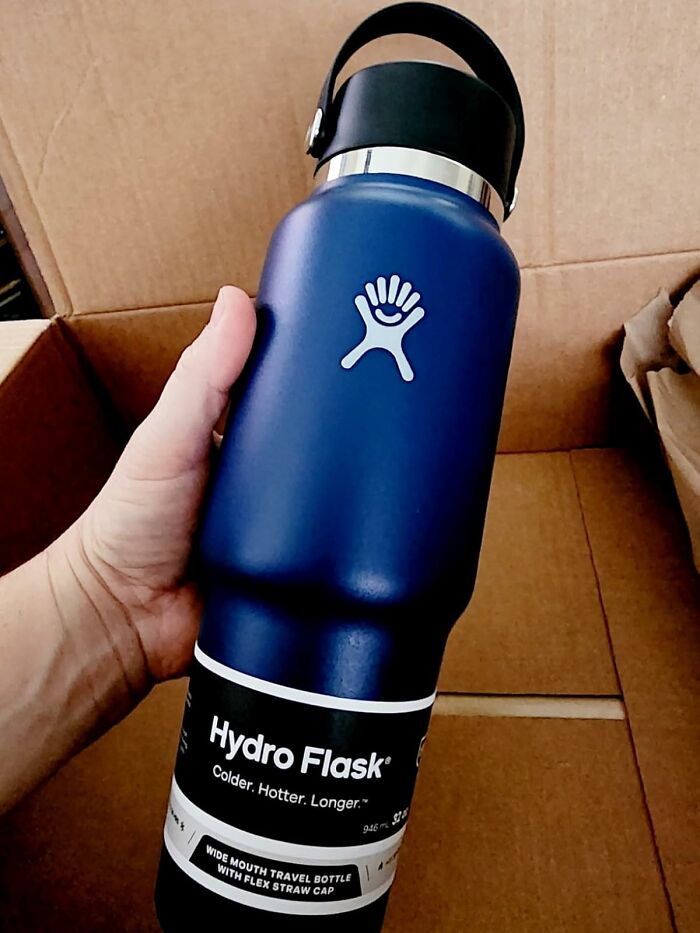 Hand holding a blue Hydro Flask water bottle inside a cardboard box during the Amazon Memorial Day Sale grab.