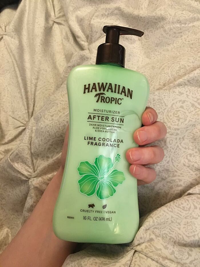 Hand holding Hawaiian Tropic after sun moisturizer with lime coolada fragrance for warm weather skin care.