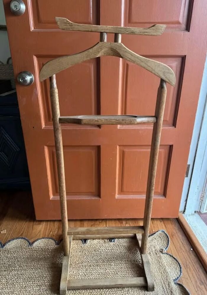 Wooden vintage clothing stand with hangers, an example of strange things found in homes with hidden or forgotten pasts.