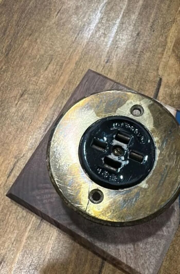 Old antique electrical outlet with brass and black parts, one of the strange things found in homes with hidden pasts.