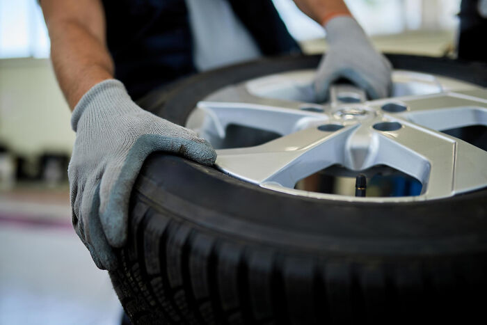 Person wearing gloves handling a tire, illustrating one of the casual things that can actually be deadly.