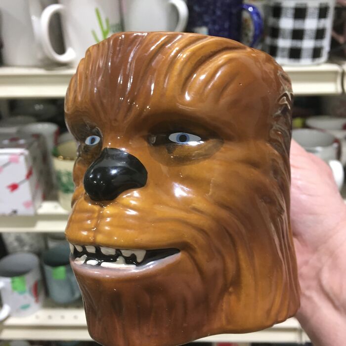 Ceramic thrifted find shaped like a whimsical creature head with detailed eyes and teeth, showcased in a vintage store setting.