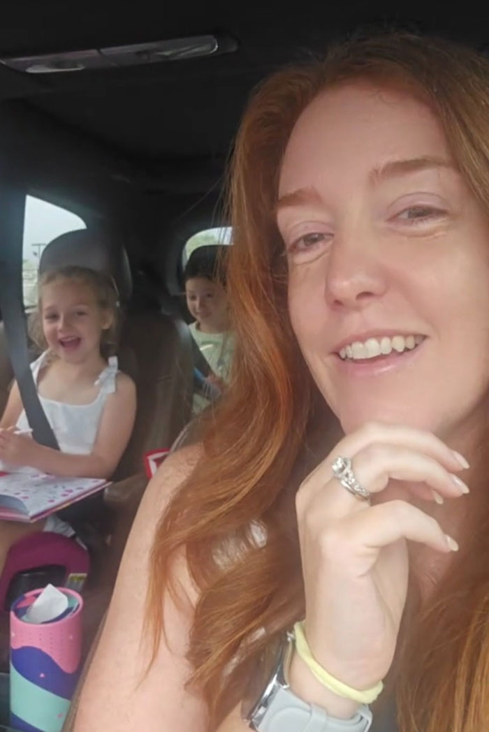 Mom with her children in a car smiling during a petty revenge moment involving family packing themselves that went viral.