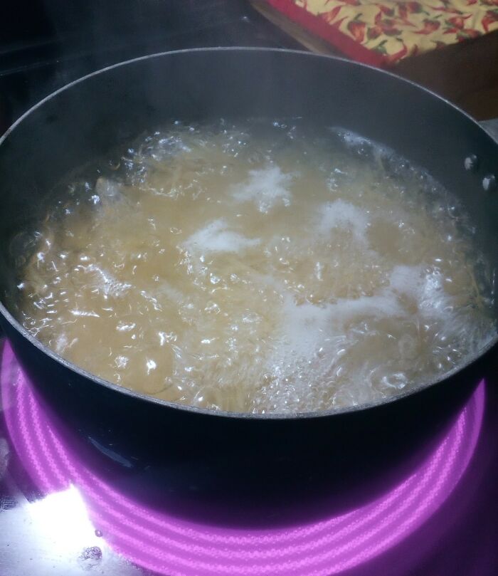 Boiling pasta on an electric stove, illustrating an excessively lazy cooking method shared by people.