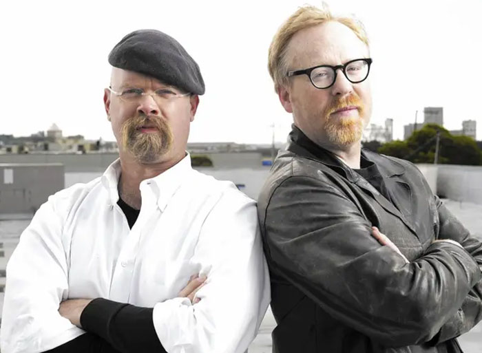 Two men with crossed arms outdoors, representing celebrity encounters that went either really well or terribly bad.