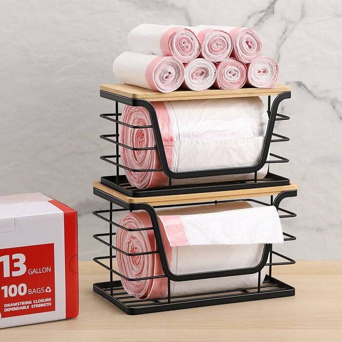 Stacked kitchen storage rack holding rolls of trash bags on a wooden surface for kitchen glow-up ideas.