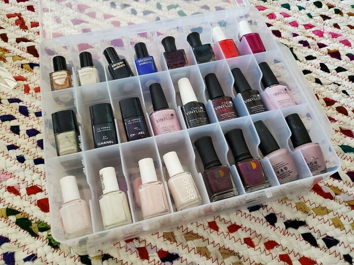 Plastic organizer box neatly holding various nail polish bottles, illustrating ways to start ditching the slob life.