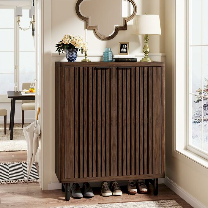 Modern wooden shoe cabinet with decorative items on top in a bright hallway, featured in Amazon Memorial Day Sale finds.
