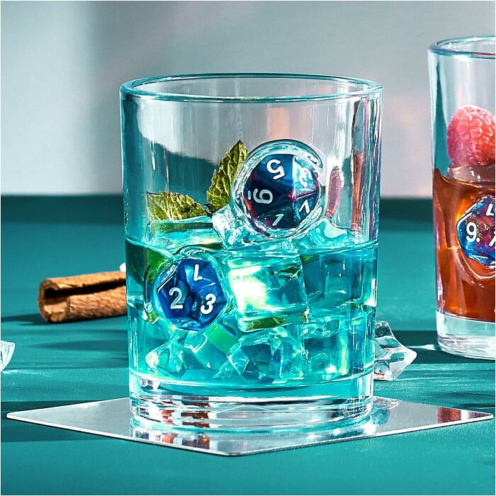 Glass with clear ice cubes and decorative dice soaking as a unique Father's Day find gift idea for men.