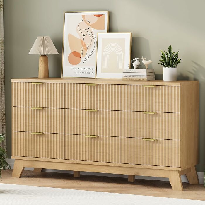 Modern wooden dresser with abstract art, table lamp, decorative birds, and plant, showcasing Amazon Memorial Day bargains.