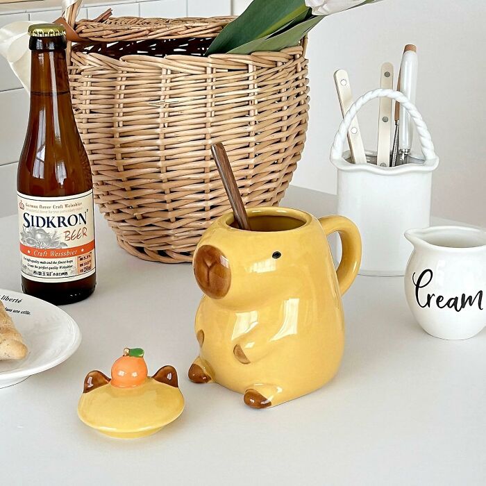 Yellow ceramic dog mug with spoon and lid, Sidkron beer bottle, cream pitcher, and woven basket on table hidden gems found
