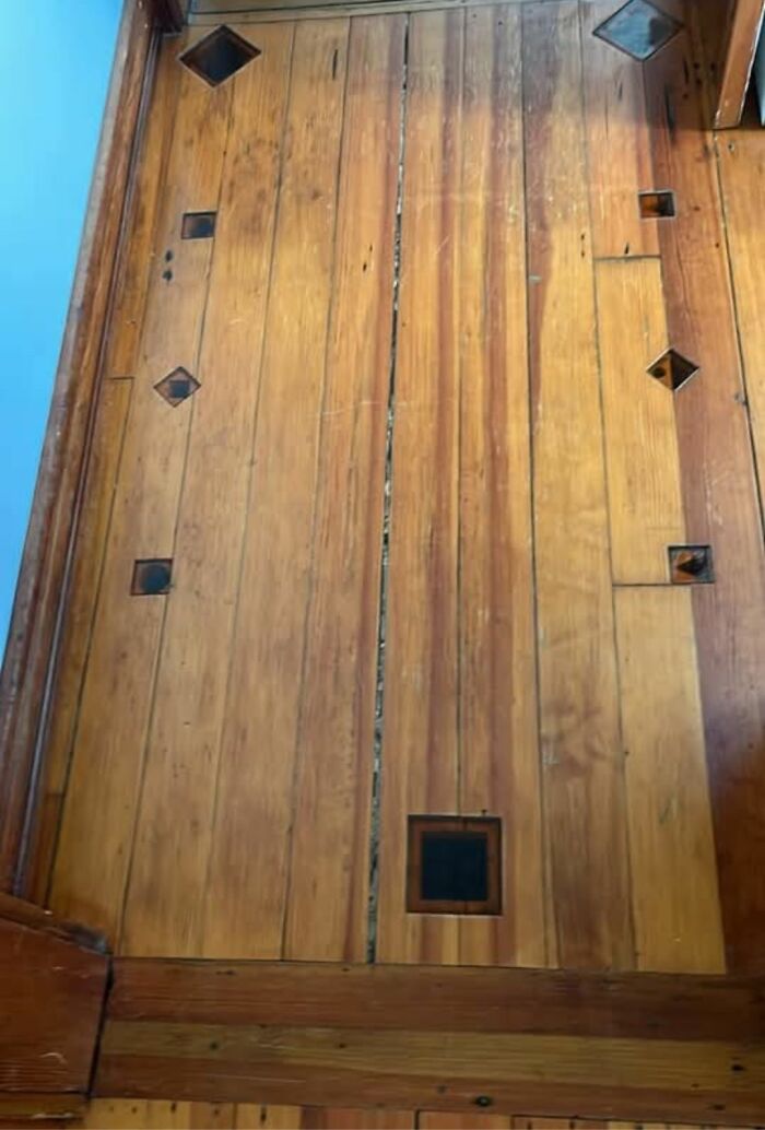 Worn wooden floor with unusual geometric cutouts found in a home with hidden and haunted pasts.