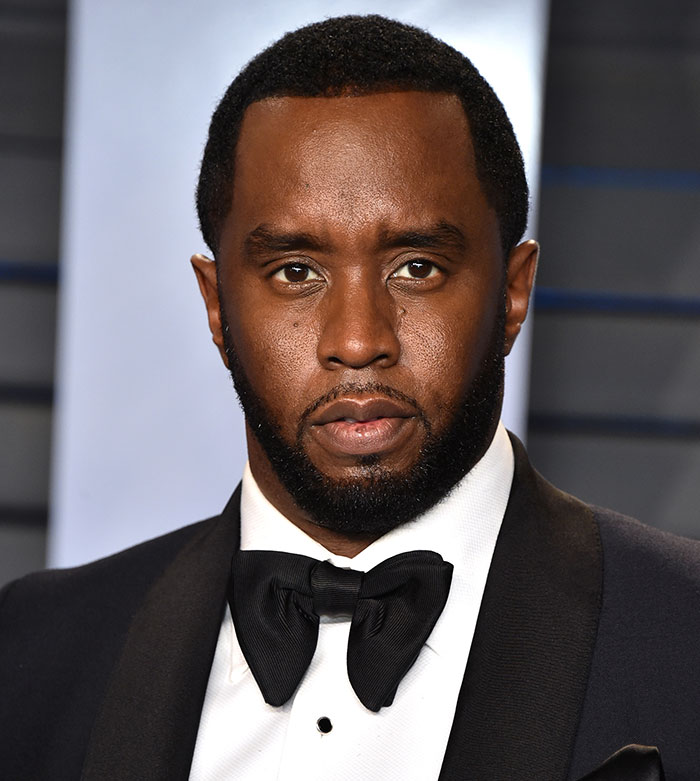 Diddy wearing a black tuxedo with bow tie, posing at an event amid major twist in Diddy case news.