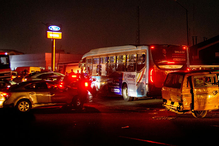 Night traffic jam with cars and a bus, capturing a tense moment that evokes a gut feeling to leave now.