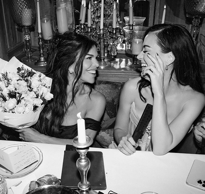 Lauren S&aacute;nchez and Kim K laughing and enjoying Lauren's bachelorette party with candles and flowers on the table.