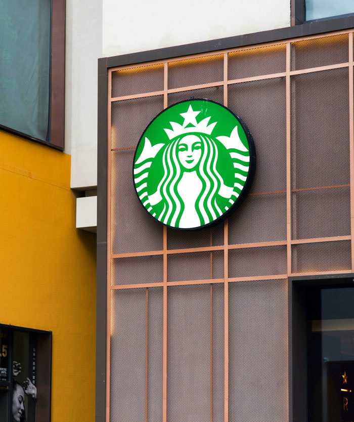 Starbucks logo on building exterior, related to former employees revealing disturbing workplace secrets after quitting jobs.