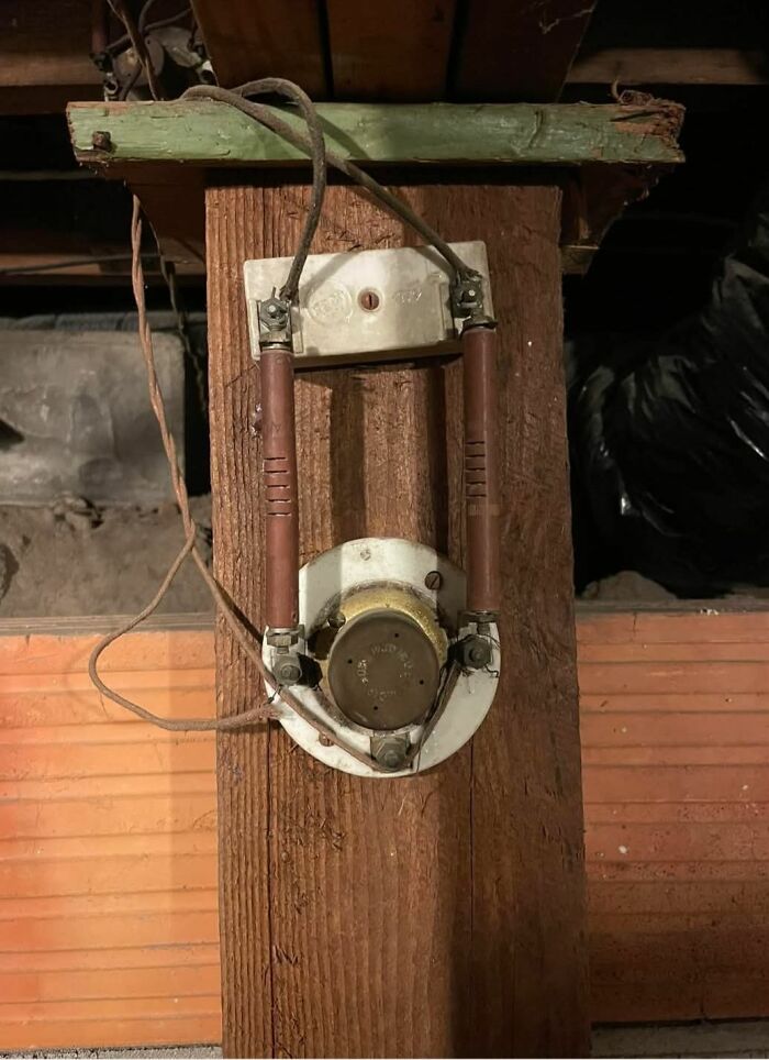 Old electrical fuse mounted on a wooden beam, one of the strange things found in homes with hidden, forgotten, or haunted pasts.