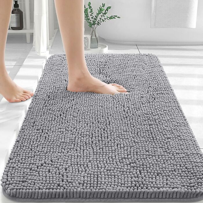 Soft gray bath mat on white floor with foot stepping on it, highlighting Amazon Memorial Day bargains home products.