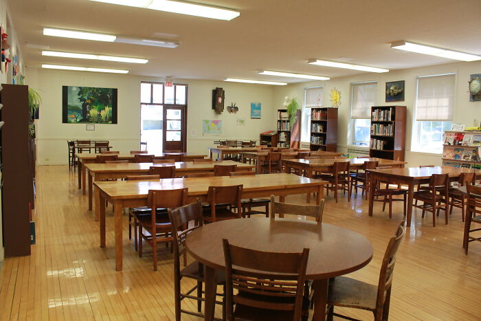 Empty library room with wooden tables and chairs, showcasing a calm space for reflection about when life gives you lemons advice.