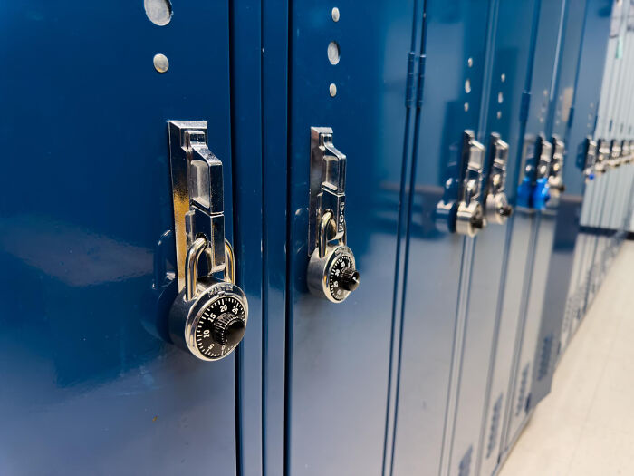 Blue lockers with combination locks in a school hallway, symbolizing keeping life blunders secret and private.
