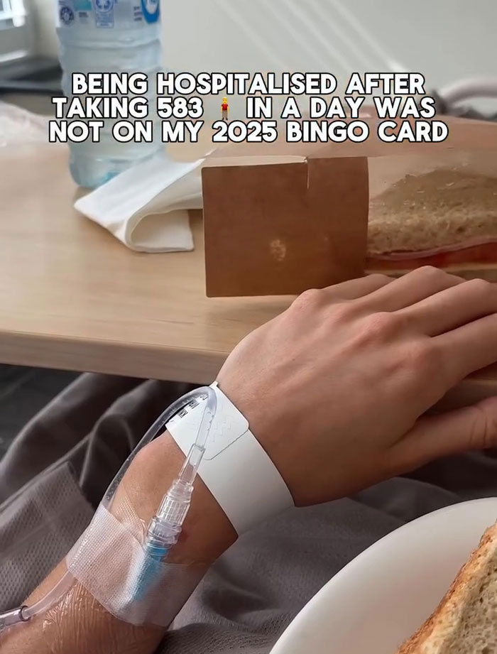 Close-up of a hand with IV drip and hospital wristband, referencing pain and bleeding after 583-man adult stunt. Close-up of a hand with IV drip and hospital wristband, referencing pain and bleeding after 583-man adult stunt.