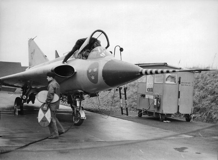Vintage plane on tarmac with technicians performing maintenance, showcasing the magic of aviation history and technology.