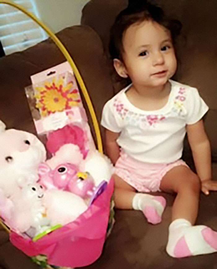 Young child sitting on couch next to a basket of plush toys, related to mom who locked 7YO starving child in closet case.