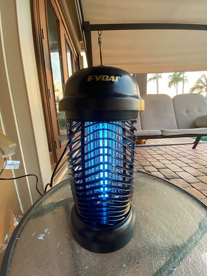 UV insect zapper on a glass table outdoors, a genius find for silencing your garden's tiny tantrums.