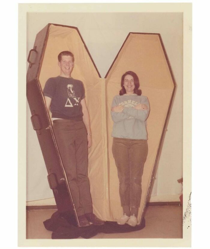Vintage photo of two people standing inside a large coffin-shaped case, showcasing interesting and mesmerizing history moments.