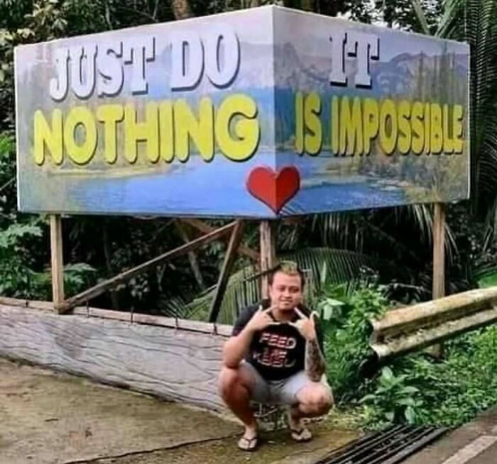 Man posing under a humorous sign with the relatable memes theme, highlighting a funny motivational message outdoors.