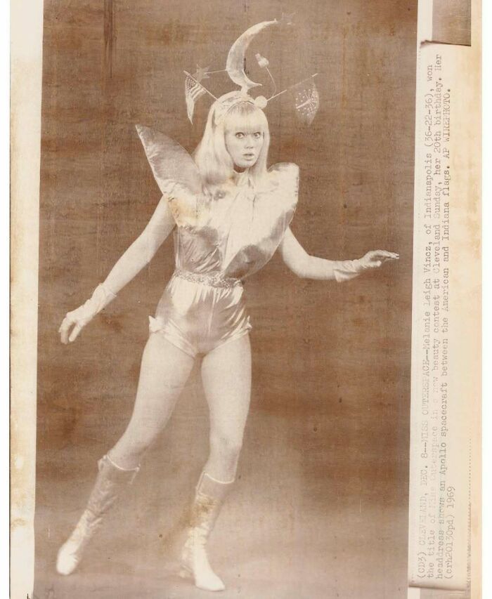 Woman in a vintage costume with futuristic design and flags, appearing in an interesting vintage photo from 1969 history.