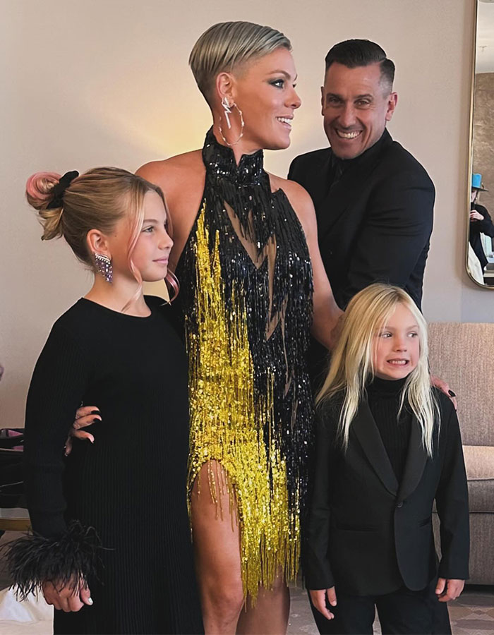 Pink with her husband and two children, dressed elegantly, highlighting support after bike accident and surgery recovery.