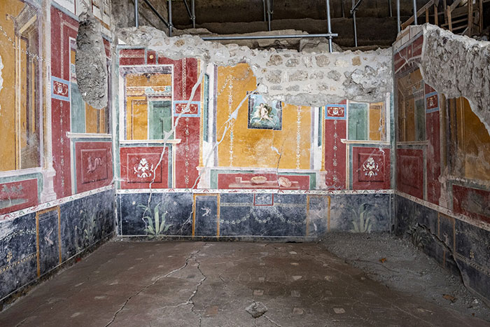 Ancient Pompeii room with colorful frescoes, related to new Pompeii discovery of parents' tragic attempt to shield child.