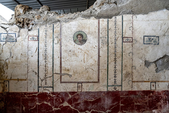 Ancient Pompeii wall painting showing part of a home interior linked to tragic parents' attempt to shield child.