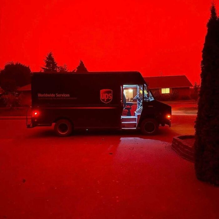 UPS delivery truck parked at night with an eerie red sky, creating unsettling yet fascinating empty spaces.