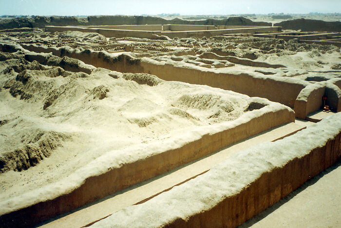 Ancient archaeological ruins of a UNESCO treasure site with sandy walls and pathways under a clear sky.