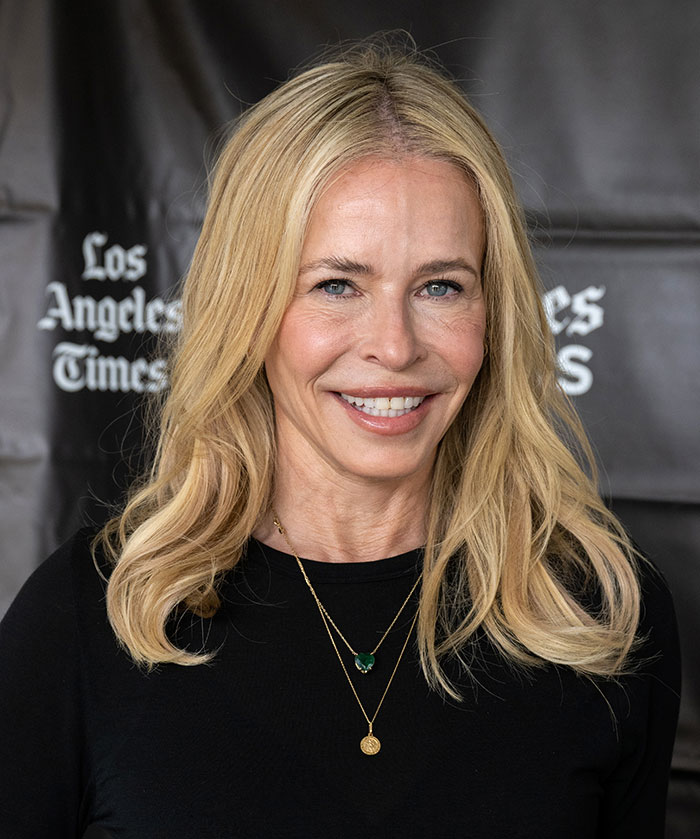 Blonde woman smiling with styled hair, wearing layered necklaces and a black top at a Los Angeles Times event.