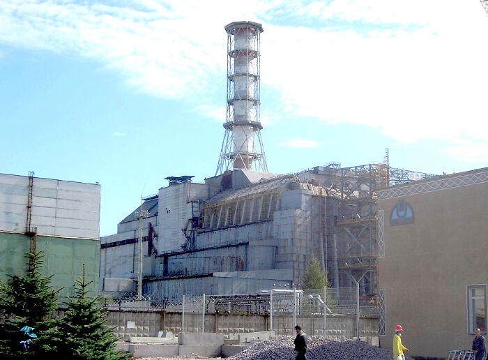 Chernobyl nuclear power plant, a historic mistake that changed the course of history, with workers and damaged reactor visible.