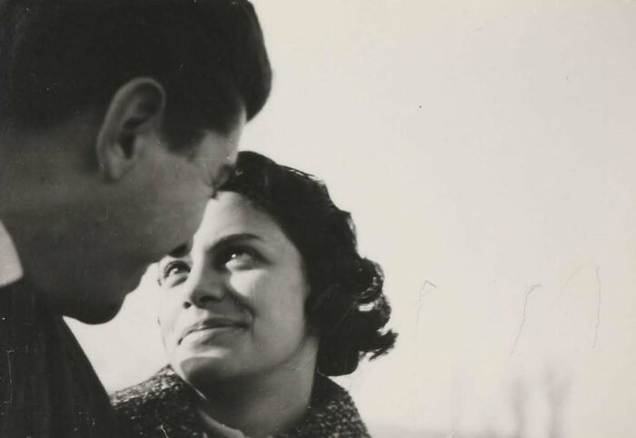 Black and white vintage photo of a man and woman sharing a close, intimate moment, showcasing mesmerising historical emotions.