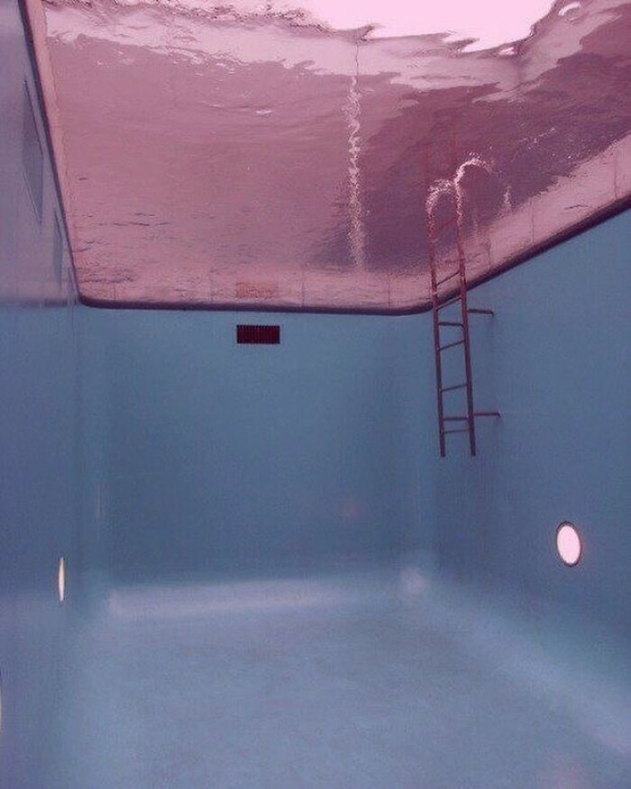 Empty pool with water surface reflecting upside down, creating an unsettling yet fascinating empty space effect.