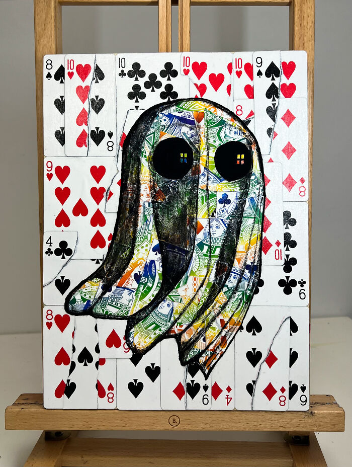 Colorful ghost illustration made with playing cards in a creative photo manipulation and collage on an easel.