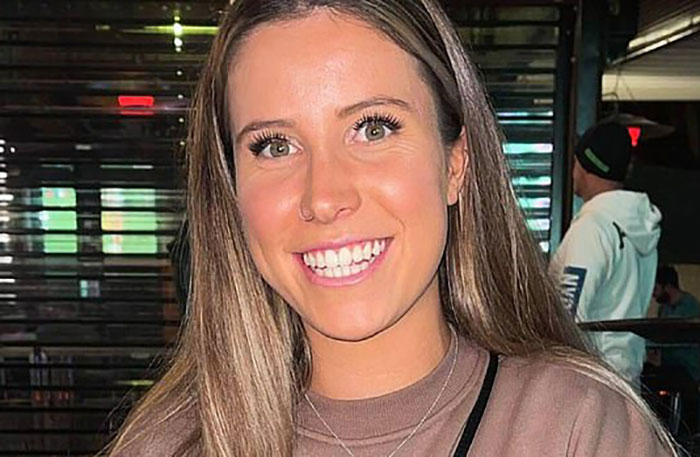 Young woman smiling indoors with long hair, relating to story about woman setting childhood male friend on fire after sexist remark