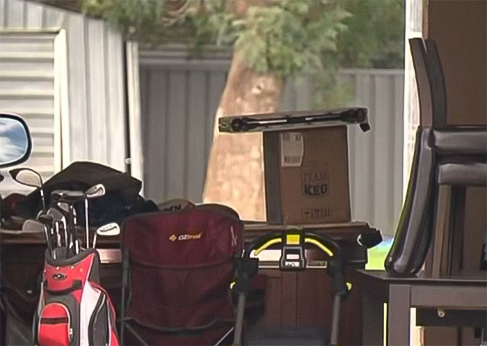 Indoor scene with stacked furniture and boxes related to a woman setting childhood male friend on fire incident.