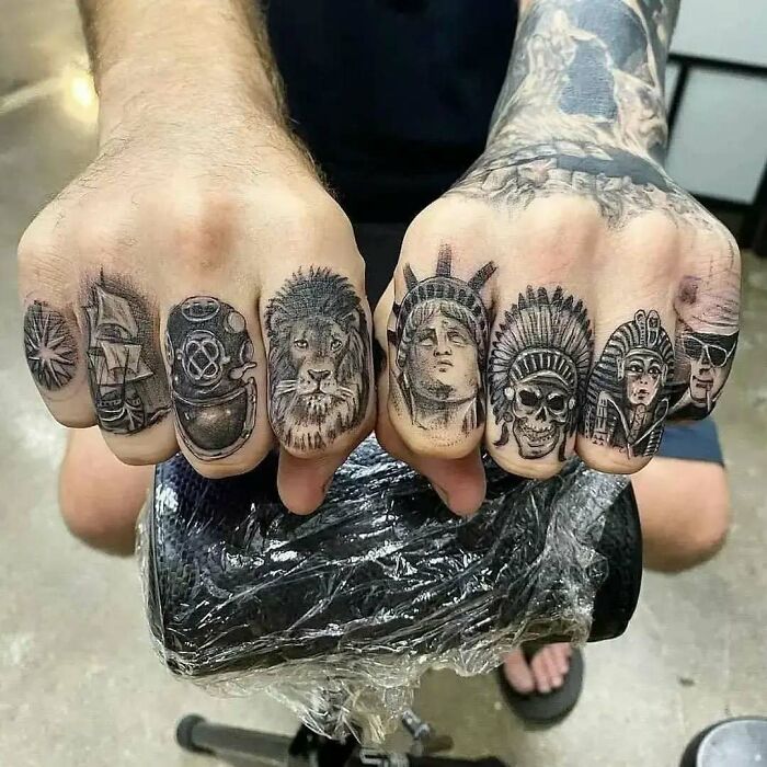 Tatuajes en los dedos con diseños de león, casco de buceo, estatua de la libertad y calavera en estilo realista y gris.