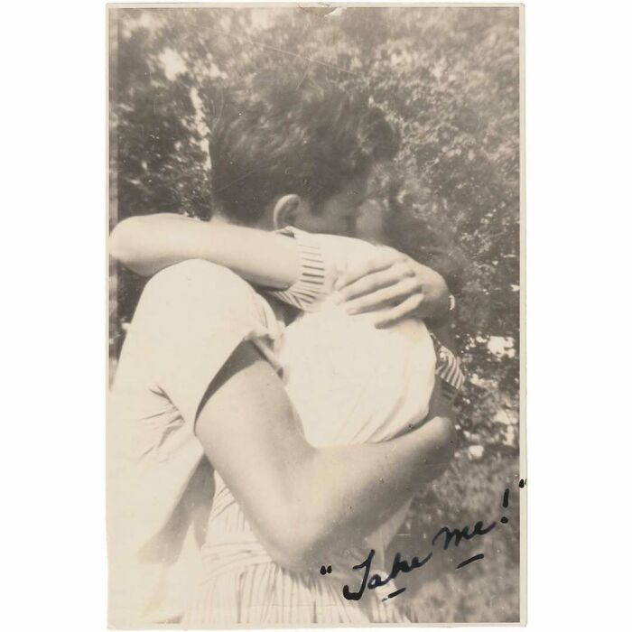 Vintage photo of a young couple warmly embracing outdoors, capturing a timeless and mesmerizing moment in history.