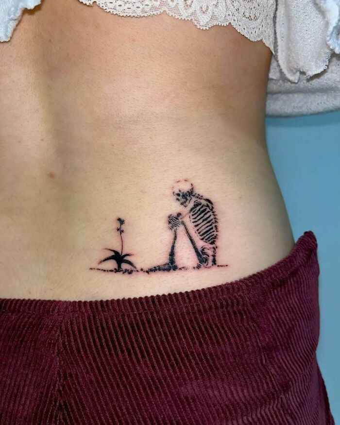 Tatuaje pequeño en costado con diseño de esqueleto y planta, ejemplo de tatuajes que van desde lo gracioso hasta lo terrible.