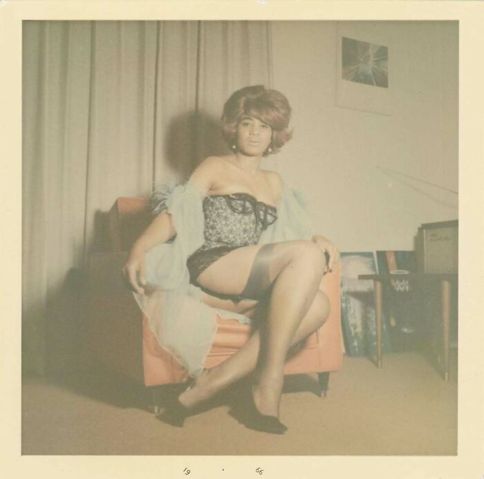 Vintage photo of a woman in retro lingerie and stockings sitting on a chair, showcasing fashion from history.